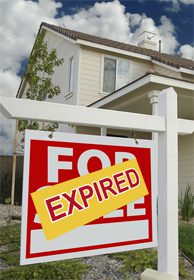 For sale sign marked expired by house.