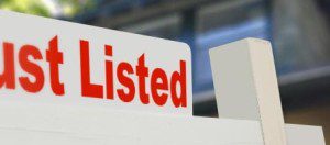 Just Listed" signpost in front of house.