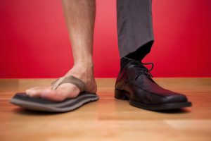 Casual and formal shoes on different feet.